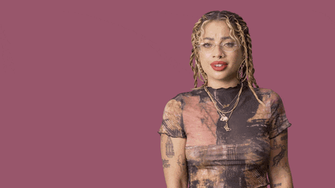 a woman with dreadlocks is making a stop sign with the word no behind her