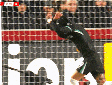 a soccer player is jumping in the air in front of a scoreboard with the time of 92:26