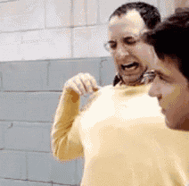 two men are standing next to each other and one is wearing a yellow sweater