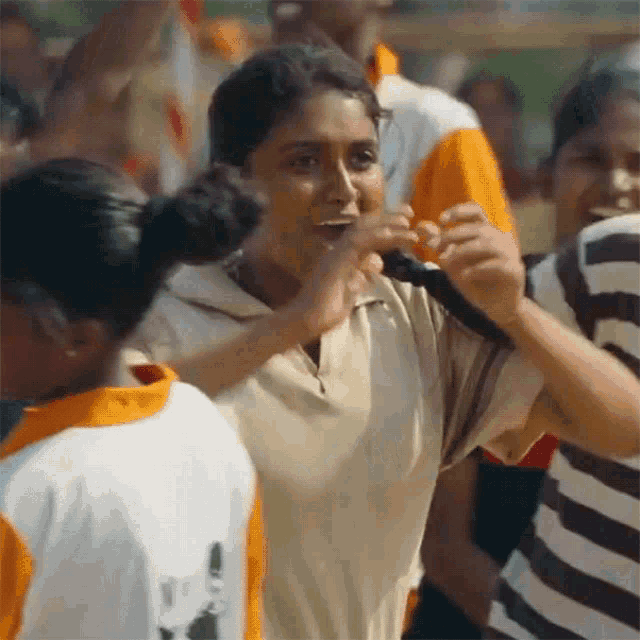 a group of people are standing around a woman in a white shirt with the word adidas on it