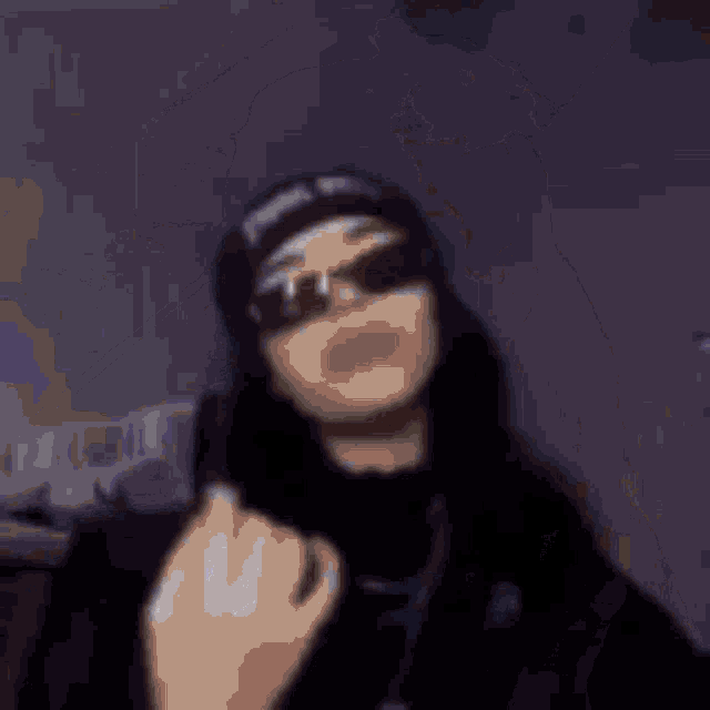 a blurry picture of a man wearing sunglasses and a hat with the word supreme on it
