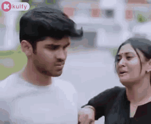 a man and a woman are standing next to each other .