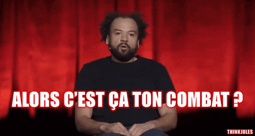 a man with a beard is sitting in front of a red curtain with the words alors c'est ca ton combat