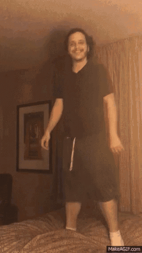 a man is jumping in the air on a bed