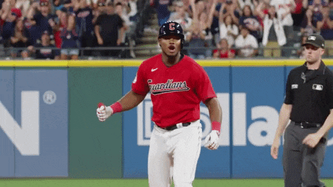 a baseball player wearing a red jersey that says indians on it
