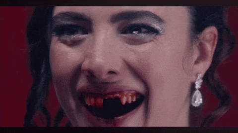 a close up of a woman 's face with bloody teeth