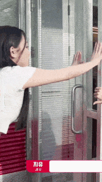 a girl is opening a door with jiu written on the bottom right