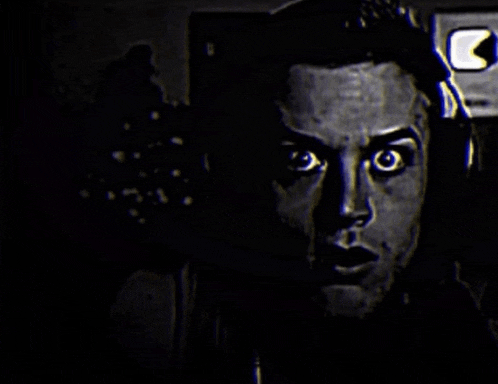 a close up of a man 's face in the dark with headphones on