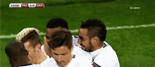 a group of soccer players are huddled together on a field with a score of 1-0 dan