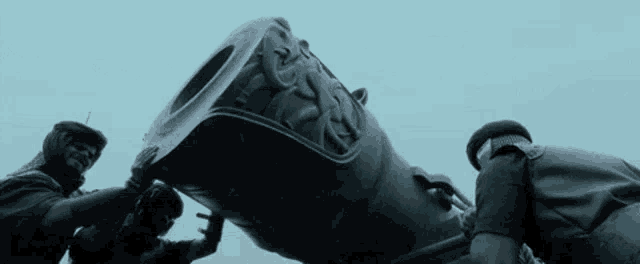 a group of men are working on a large cannon with the letters tc on it