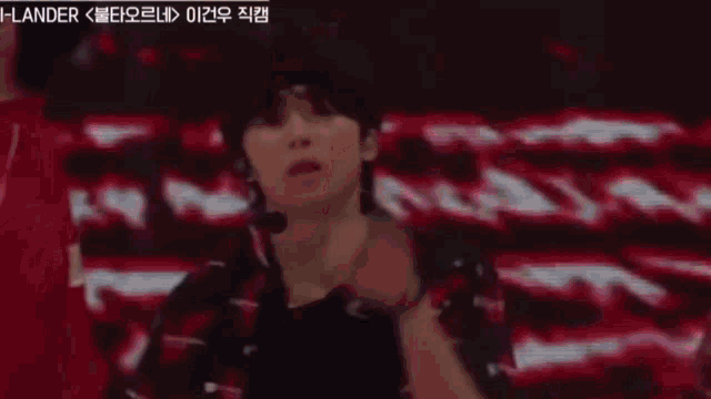 a person is dancing on a stage with a red background .