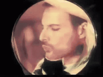 a close up of a man 's face in a circle with a cat in the background .