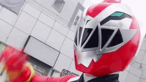 a red and silver helmet is being worn by a person in a red costume .