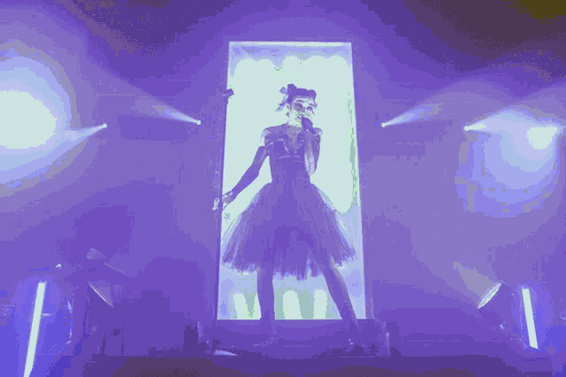 a woman in a black dress is singing into a microphone