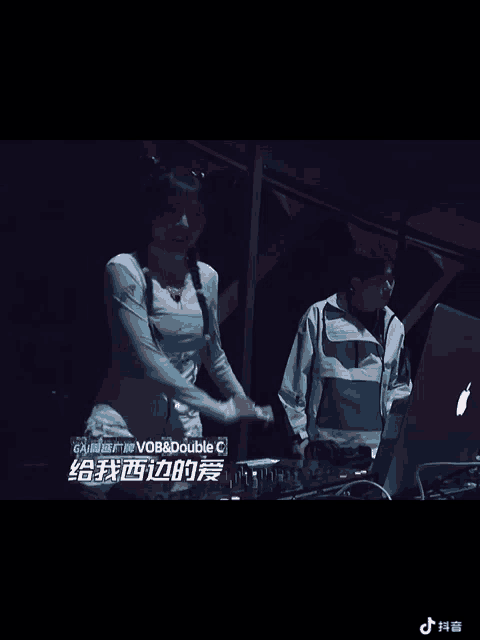 a man and a woman are dancing in front of a laptop that says double c