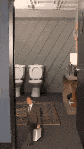 a man in a suit carrying a briefcase walks through a bathroom with three toilets