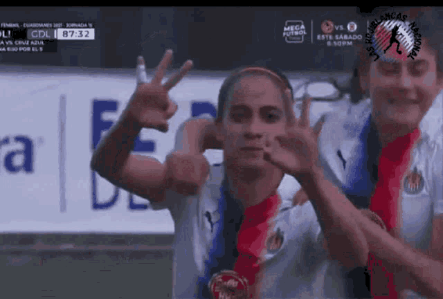a female soccer player giving a peace sign during a match