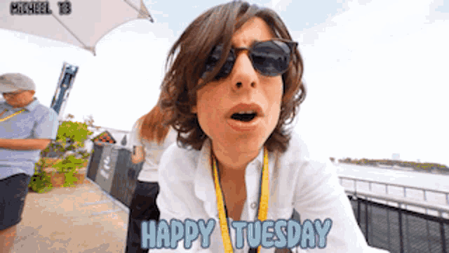 a person wearing sunglasses says happy tuesday