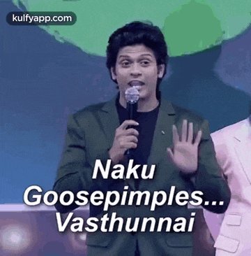 a man in a suit is holding a microphone and saying `` naku goosepimples ... vasthunnai '' .