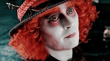 a close up of a person 's face wearing a hat and red hair .