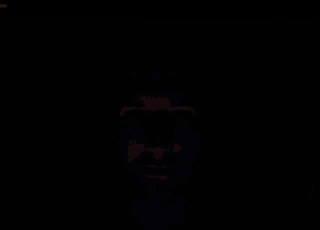 a close up of a man 's face in the dark with a beard