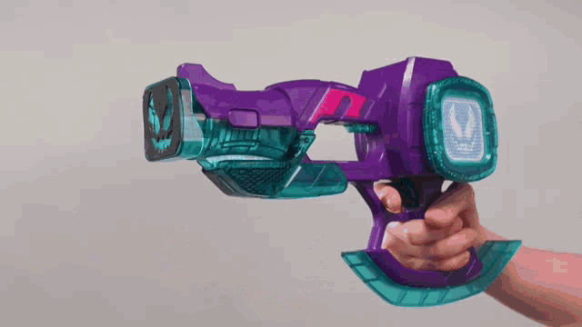 a person is holding a purple toy gun with a lightning bolt on it