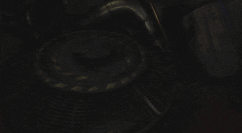 a dark room with a staircase and a metal grid