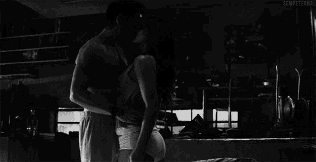 a black and white photo of a man and woman kissing with the words sempeternal below them