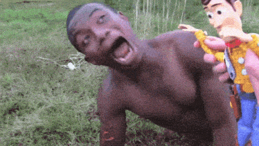 a shirtless man is holding a toy story woody doll in his hand