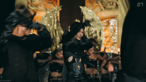 a group of people are dancing in a room with the letter s on the bottom right