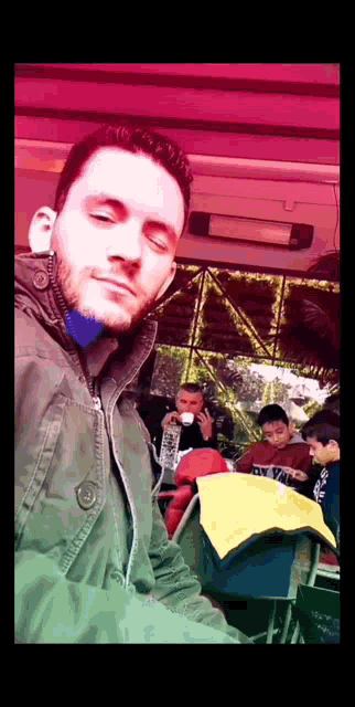 a man in a green jacket is taking a picture of himself in a restaurant