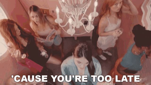 a group of women are gathered around a chandelier with the words ' cause you 're too late ' on the bottom