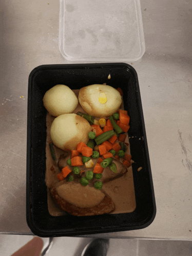 a tray of food with potatoes carrots green beans and peas