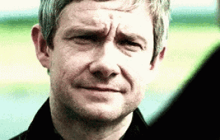 a close up of a man 's face with a slight smirk on his face .