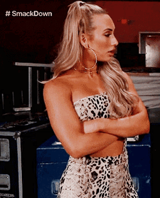 a woman in a leopard print dress with her arms crossed .