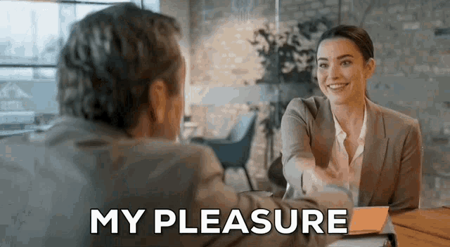 a woman is shaking a man 's hand in a job interview .