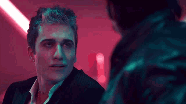 a man in a suit is talking to another man