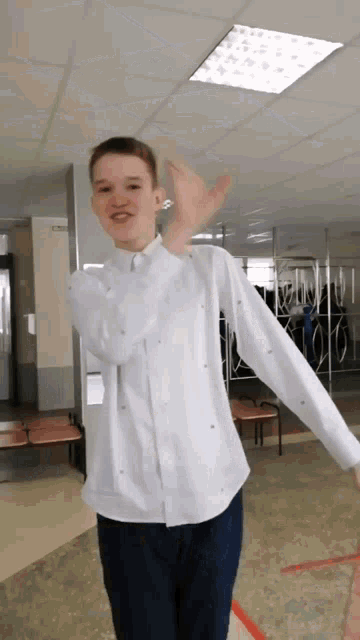 a young man in a white shirt and blue pants is dancing
