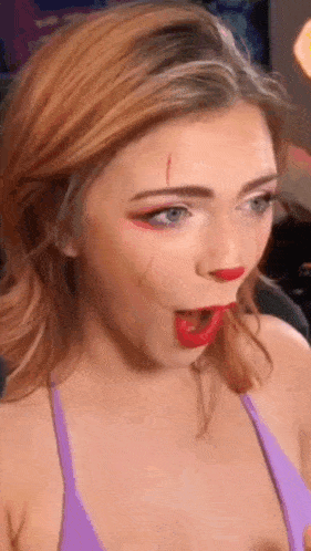 a woman in a bikini is wearing red lipstick and making a face .