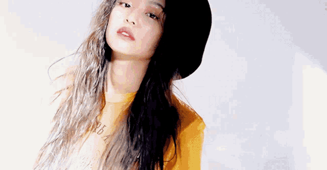 a woman wearing a hat and a yellow shirt with the word nba on it