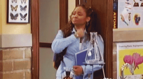 a woman is standing in a hallway next to a beaker and a book .