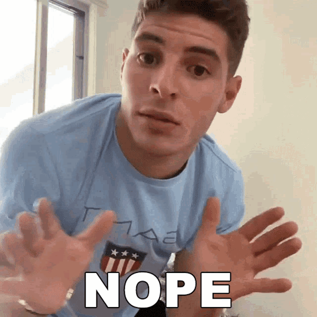 a man in a blue shirt says nope with his hands out