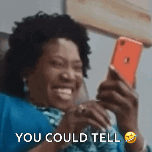 a woman is laughing while looking at her phone with the words you could tell written below her