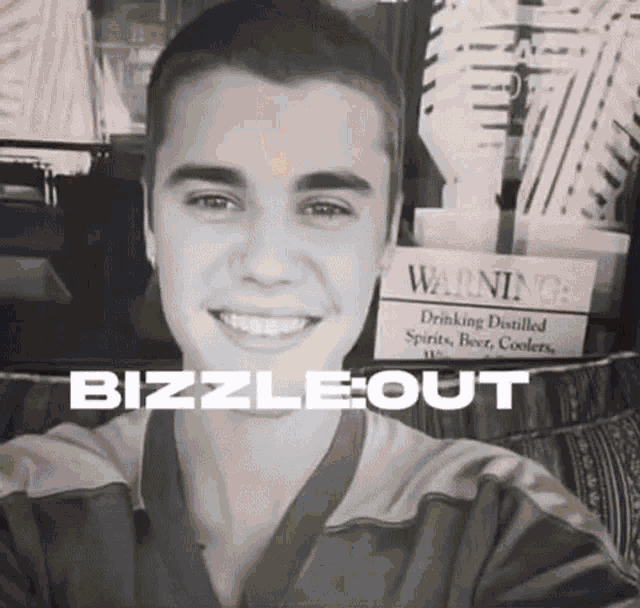 a young man is smiling in front of a sign that says warning drinking distilled spirits beer and coolers