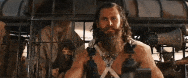 a man with a beard is standing in a cage with other people