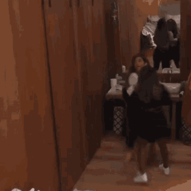 a couple of women standing next to each other in a bathroom .