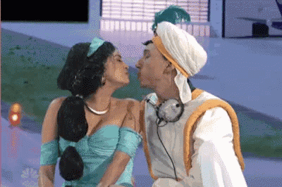 a man in a turban kisses a woman in a dress