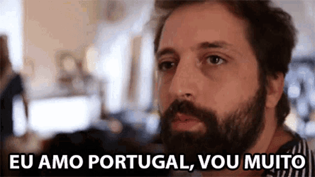 a man with a beard is saying eu amo portugal vou muito .