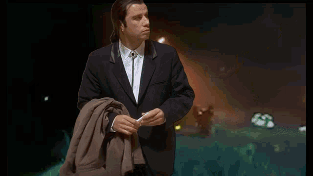 a man in a suit and tie is holding his jacket