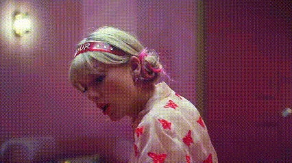 a woman wearing a headband and a pink shirt is standing in a room .